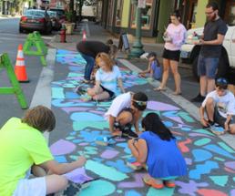 group of kids painting a sidewalk