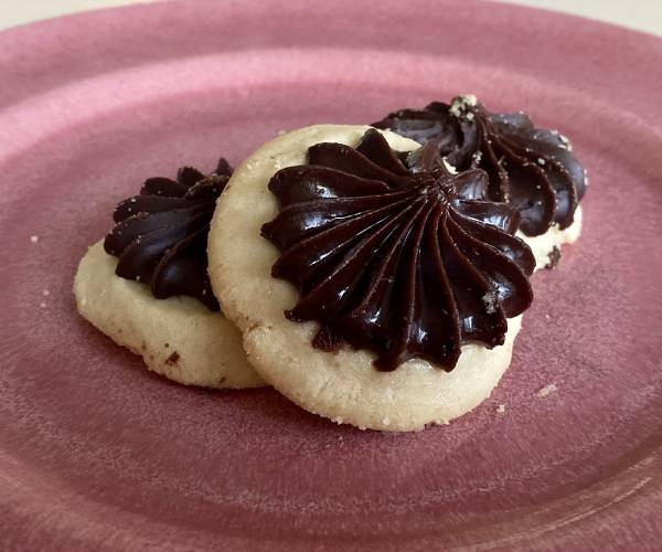 3 cookies with chocolate frosting on red plate