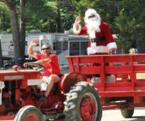 santa waves from wagon being pulled by a tractor