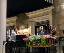 couple dines on restaurant patio near salt and char sign