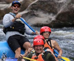 four people whitewater rafting, one is a guide