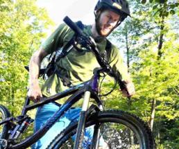 man in helmet with mountain bike in the woods