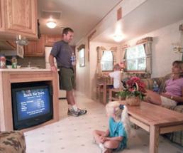 family inside luxury rv trailer with tv and living room area