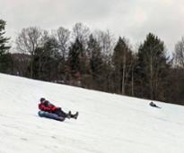 people tubing down a snowy hill