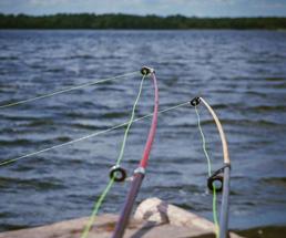 Two cast fishing poles over water