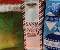 closeup of gift bags, one says santa stop here