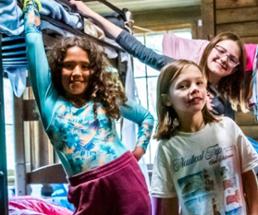 three girls by bunkbed at summer camp