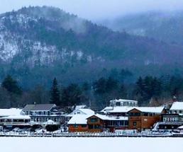 winter scene with lodging and mountain behind it