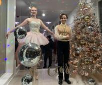 two girls dressed up in nutcracker attire in a storefront