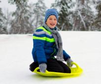 kid with sled in snow