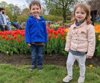 two small kids pose by tulips at albany tulip fest