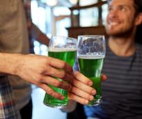 people holding glasses of green beer