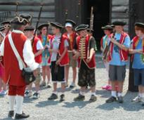 kids dressed up in historic solder attire at a fort museum