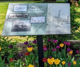 glens falls city park sign with tulips under it