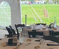 tables set up for wedding reception in tent on campground