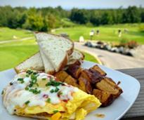 breakfast plate with omelette, breakfast potatoes, and toast overlooking golf course