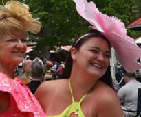 two women wearing fancy hats at the track