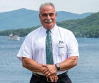 Sam Luciano standing in front of Lake George