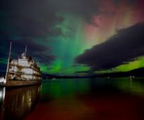 northern lights over a lake and ship