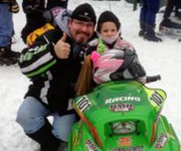 man with little girl on snowmobile