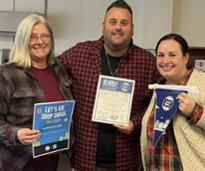 three people hold up small business saturday signs