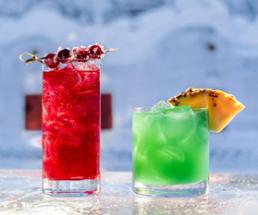 two colorful cocktails on ice bar