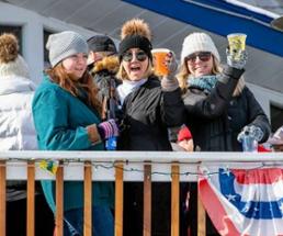 people outside lake george beach club with drinks in winter