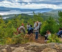 people at mountain summit overlooking lake