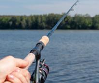 a fisherman holding a pole over a lake