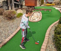 kid plays mini golf