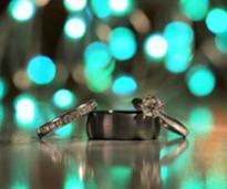 turquoise lights behind wedding rings