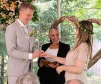 two people smiling as they get married by a smiling officiant