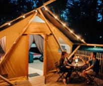 couple on porch of glamping tent/cabin