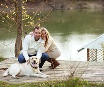 Couple with dog on a dock at the lake