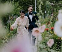 bride and groom runs laughing through garden