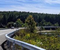 car on road by water in adirondacks