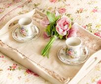 tray with two teacups and a bouquet of pink flowers