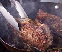 steak being turned in a skillet