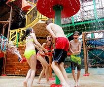 four kids playing in an indoor waterpark