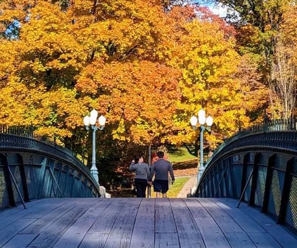 couple walks over Washington Park bridge in the fall