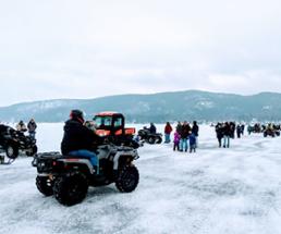 people and ATVs on a frozen lake