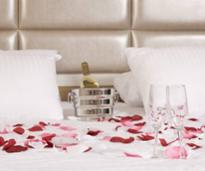 bed set up with champagne and flower petals