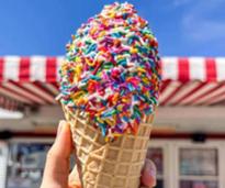 hand holding ice cream cone with rainbow sprinkles