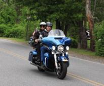 a man and woman riding a blue motorcycle