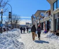 people walking down the street in lake george village in winter