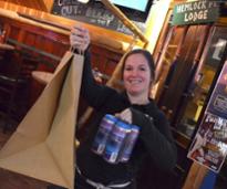 woman holding brown bag and beer