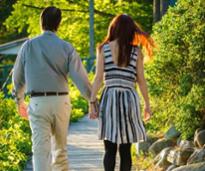 the back of a couple walking hand in hand