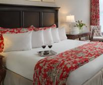 inn room with wine glasses on bed