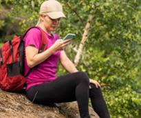 woman on cell phone on rock