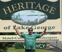 man poses in front of lodging sign